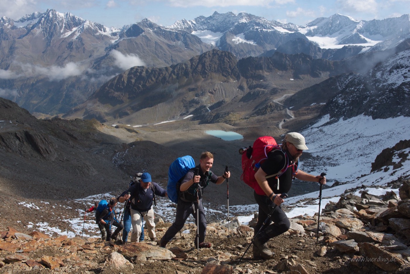 Narrow trail along a rock face, a turquoise mountain lake below