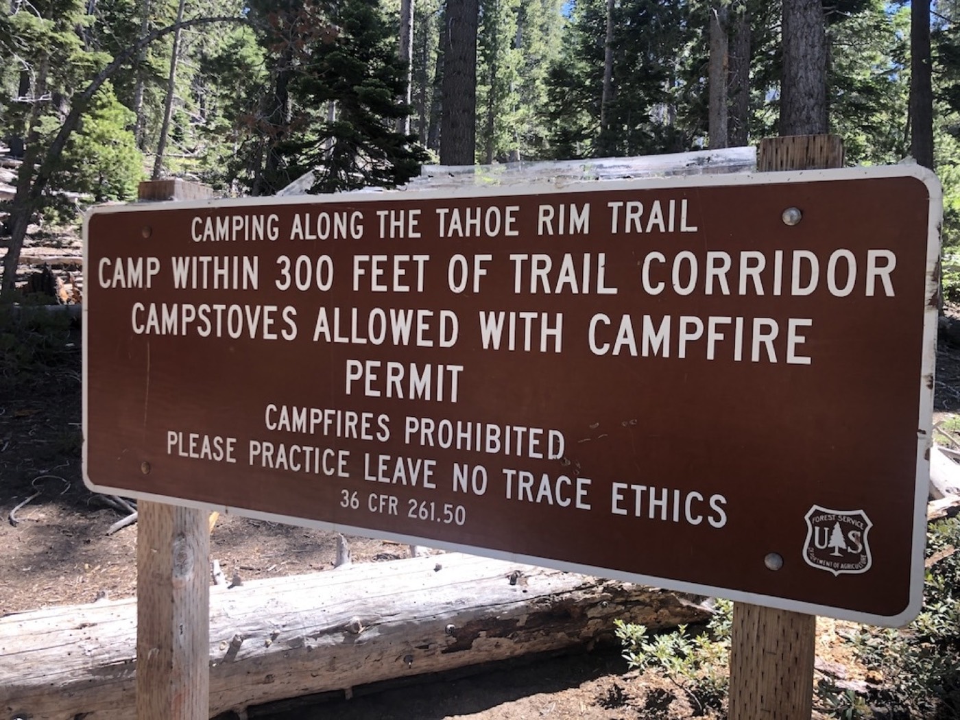 Tafel des US Forest Service: Camping entlang des Tahoe Rim Trails nur innerhalb von 300 Fuß zum Weg, Kocher mit Genehmigung erlaubt, Lagerfeuer verboten, „Leave No Trace" beachten