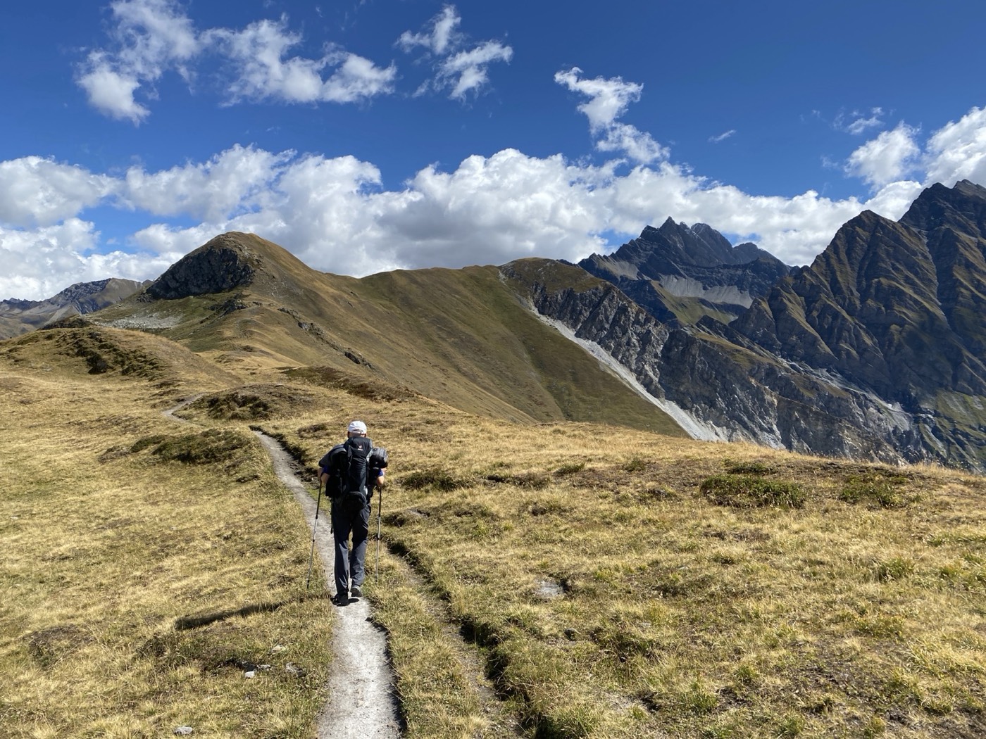 Wanderer auf einem Grat, dahinter das Bergpanorama der Savoyer Alpen